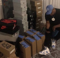 a man sitting on a couch next to boxes of shoes